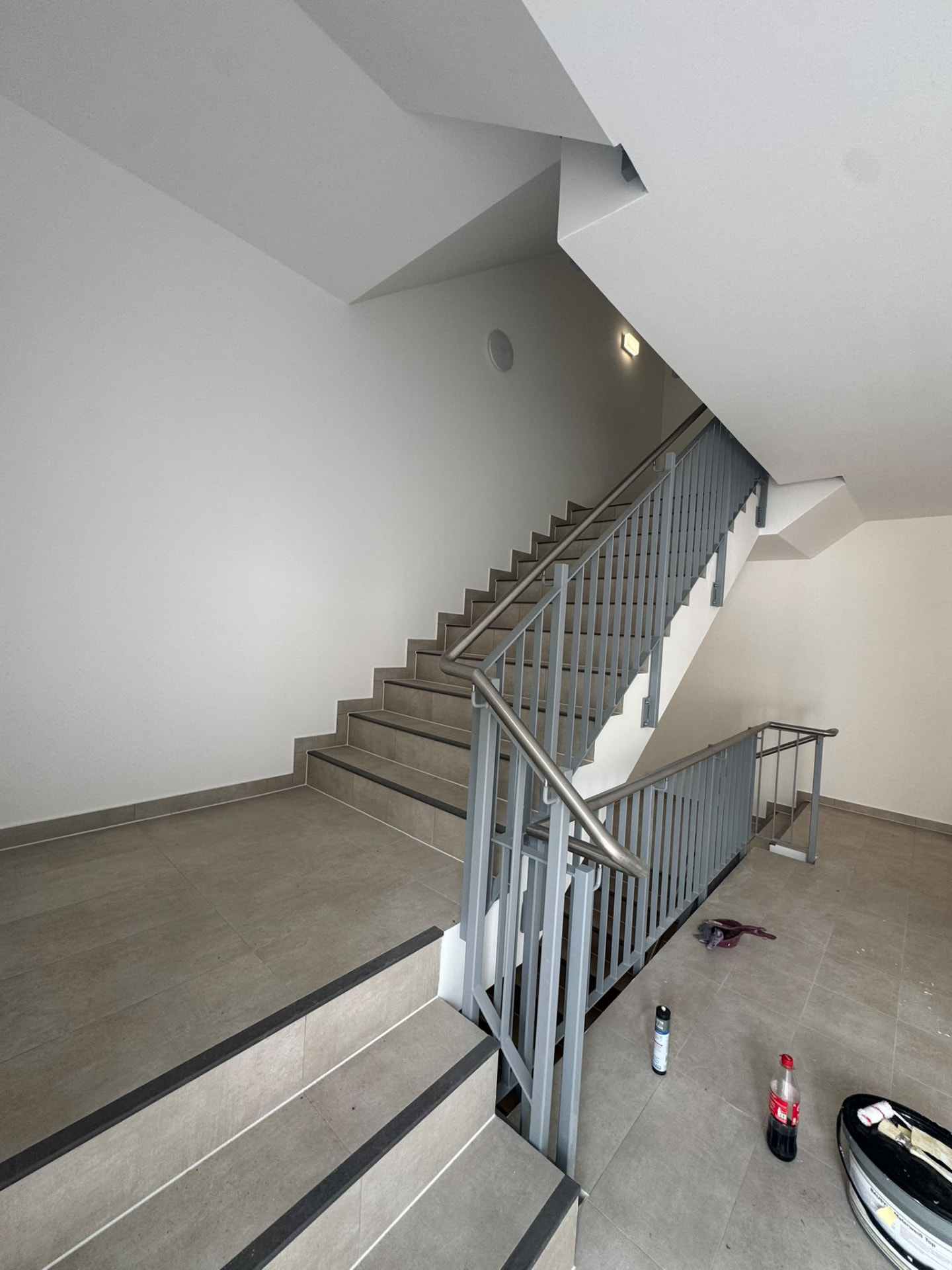 Fertiggestelltes Treppenhaus mit Fliesen und Metallgeländer